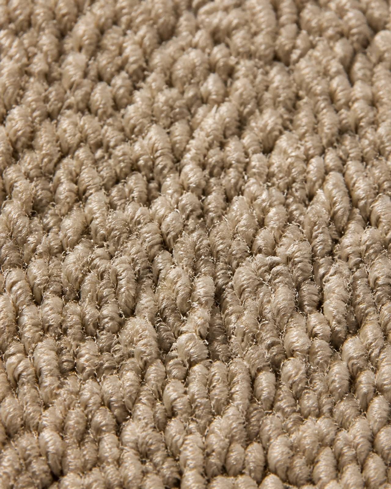 Macro close-up of high-quality greige carpet fibers showing intricate texture and durability